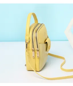 Side view detail of yellow mini crossbody bag featuring stone pattern front pocket