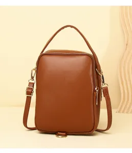 Detailed front view of brown leather mini crossbody phone bag with gold zipper