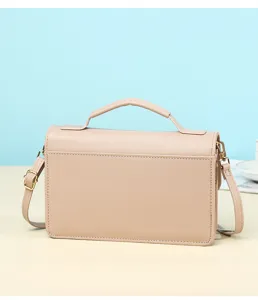 Back view of minimalist nude pink crossbody bag showing pebbled leather texture and top handle