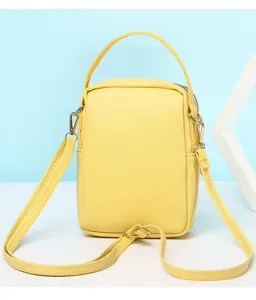 Back view of a vibrant yellow mini crossbody bag showing handle and shoulder strap