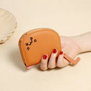 Detail of orange cartoon cat coin purse with embroidered face and zipper pull