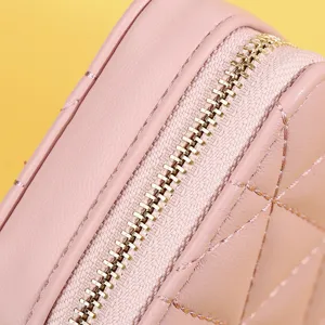 Detailansicht einer rosa gesteppten Lippenstift-Tasche mit goldenem Reißverschluss