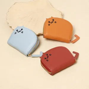 Macro view of cute cartoon cat-shaped small wallets in three colors with tail zipper pulls