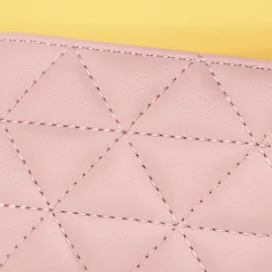 Nahaufnahme der feinen Nähte und des rosa gesteppten Leders an einer kleinen Kosmetiktasche