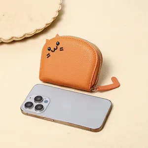 Cute orange cartoon cat coin purse shown next to a smartphone for size reference