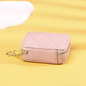 Detailaufnahme einer rosa gesteppten Mini-Lippenstifttasche mit goldenem Schlüsselanhänger