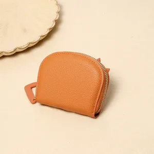 Close-up of orange pebbled leather coin purse with cute cat ear details
