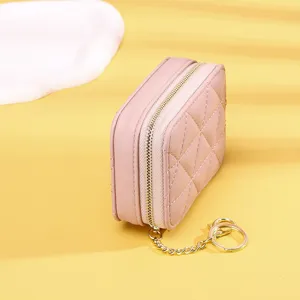 Detailansicht der Seite und des goldenen Schlüsselanhängers einer rosa gesteppten Mini-Tasche