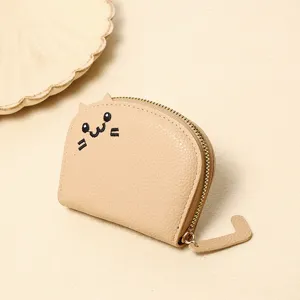 Detailed close-up of a cute beige cat-shaped coin purse with embroidered face and tail zipper