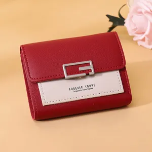 Detailansicht eines stylischen roten und pinken Mini-Damenportemonnaies mit G-Schnalle.