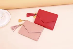 Detailed view of pink and red women's slim wallets with tassel and heart charm.