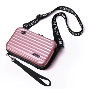 Stylische rosa Mini-Koffer-Umhängetasche mit robuster PC-Hartschale und Logo-Schultergurt.