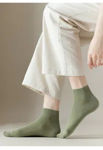Close-up view of light green ribbed ankle socks worn by model, highlighting the soft knit texture.