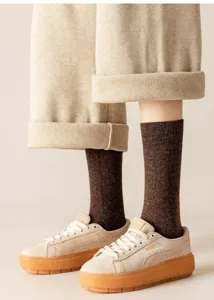 Calcetines largos de invierno de lana abrigados con pantalones y zapatillas de ante.