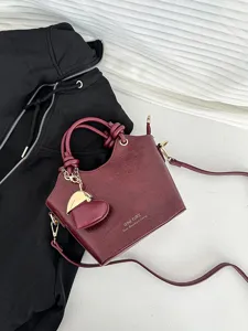 Elegante borsa a secchiello bordeaux effetto coccodrillo per donna con ciondolo a cuore