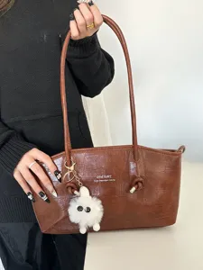 Elegant brown crocodile pattern tote bag for women with a cute white fluffy monster keychain
