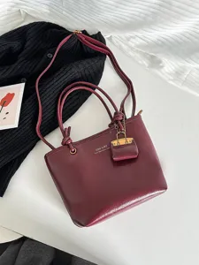 Vintage burgundy leather tote bag with shoulder strap and matching mini charm pouch accessory