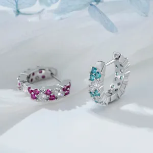 Detailed macro shot of micro-set zircon hoop earrings with red and blue crystals