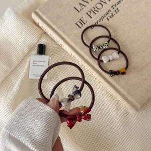 Close-up shot of five elegant elastic hair ties featuring colorful bow designs