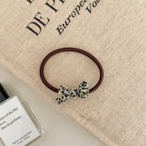Detail view of a brown elastic hair tie with a stylish leopard print bow ornament.