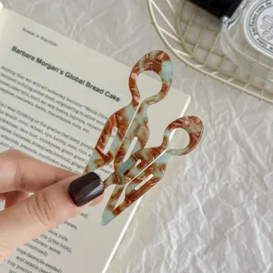 Detail of acetate marble pattern fish-shaped U-shaped hair pins for bun styling