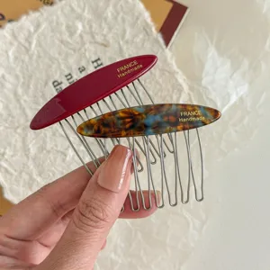 Detail of acetate side hair combs in wine red and tortoiseshell patterns