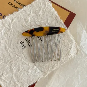 Close-up of vintage tortoise shell acetate hair comb with FRANCE Handmade gold lettering