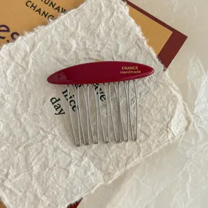 Close-up of red acetate hair comb with gold FRANCE Handmade lettering and metal teeth