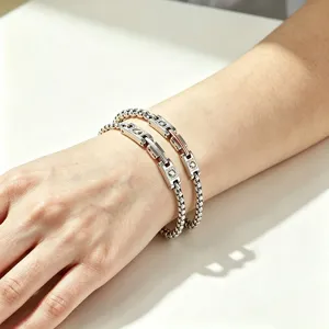 Close-up detail of a silver stainless steel watchband style bracelet worn on a wrist