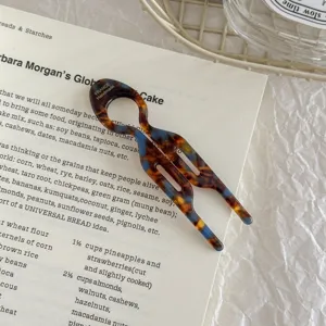 Macro view of a U-shaped acetate hair stick with tortoiseshell and blue marble patterns
