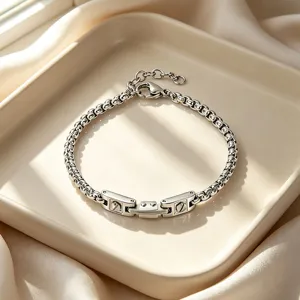 Macro view of a silver stainless steel bracelet with watchband-style link detail.