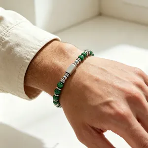 Primo piano di un bracciale da uomo in malachite con dettagli in acciaio inossidabile.