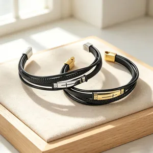 Macro detail of men's multilayer braided leather bracelets with cross-engraved plates
