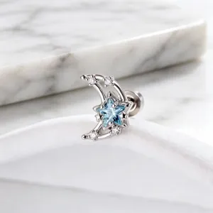 Detailed macro view of a sparkling crescent moon and blue star stud earring in silver