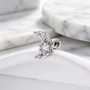 Detailed macro shot of a sparkling star and moon stud earring with clear zircons.