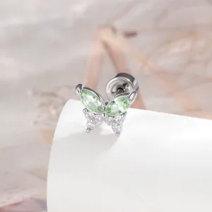 Macro view of titanium butterfly stud earring with sparkling green and clear gems
