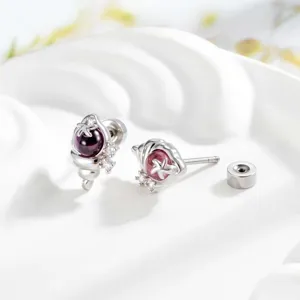 Macro view of ocean-themed conch shell stud earrings with purple gems and zircon inlay