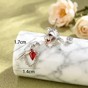Detail view of bird-shaped earrings with red rhombus zircon and 1.7cm x 1.4cm size specs.