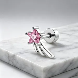 Detailed view of a silver star stud earring with a pink zirconia on a marble surface