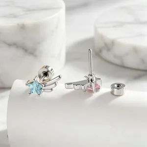 Detailed macro view of silver wing earrings with blue star zircon and secure backings