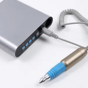 Macro detail of portable electric nail drill set featuring gold handpiece and silver power box