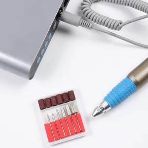 Macro detail showing portable electric nail drill cable connection and metal bit set