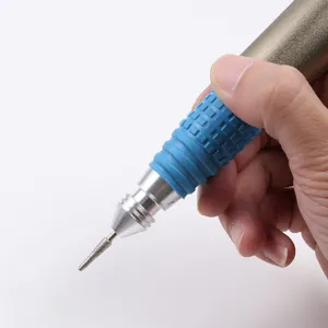 Detailed view of a portable metal nail drill handle with a precision grinding bit attached