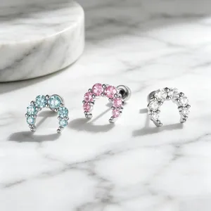 Macro detail shot showing three colors of sparkling crescent moon cubic zirconia ear bone studs