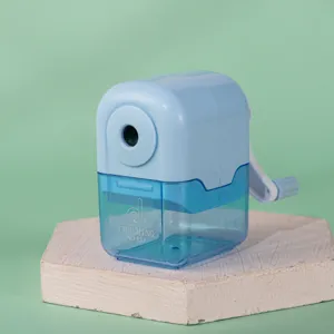 Closeup of a light blue manual pencil sharpener with transparent waste bin and hand crank.