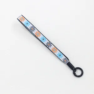 Nahaufnahme des böhmischen Jacquard-Lanyards mit buntem Gänseblümchenmuster und Metallring