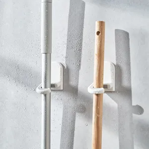 Weißer minimalistischer Wandhalter für Mopp und Besen an einer nassen Badezimmerwand