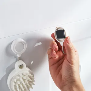 Gancio magnetico bianco minimalista per frigorifero senza foratura, mostrato in mano.