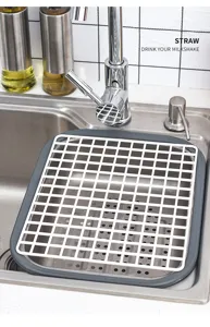 Rejilla de drenaje rectangular de plástico blanco con marco gris en fregadero de acero.