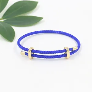 Primer plano de una pulsera de alambre trenzado azul con deslizador dorado ajustable